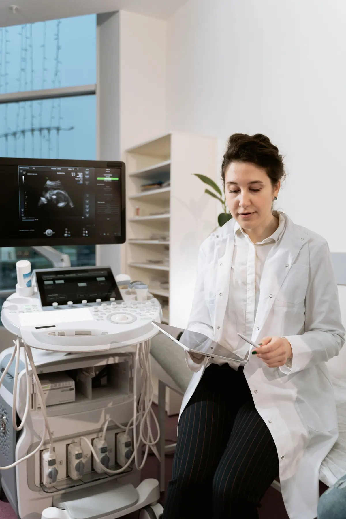A clinician working at an ultrasound scanner in a clinic imaging room